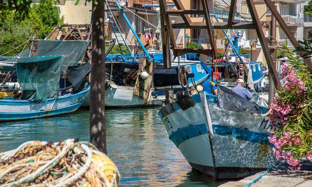 Gezeichnet von Salzwasser, mit dicken Netzen an Deck: Fischerboote am Kanal Richtung Lagune.