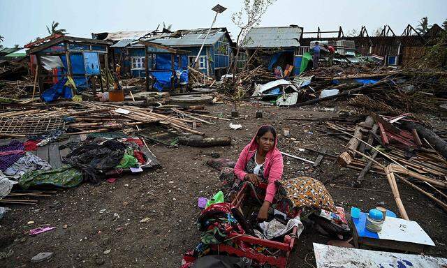 Eine Frau in einem Flüchtlingslager in Sittwe vor zerstörten Häusern. In Burma wütete der heftigste Zyklon seit mehr als einem Jahrzehnt.
