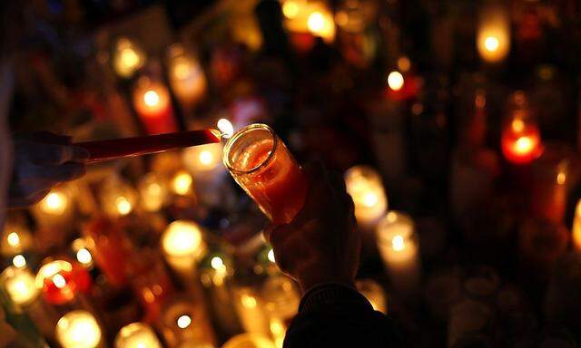 A candle is lit at a memorial for Sandy Hook Elementary School shooting victims in Newtown