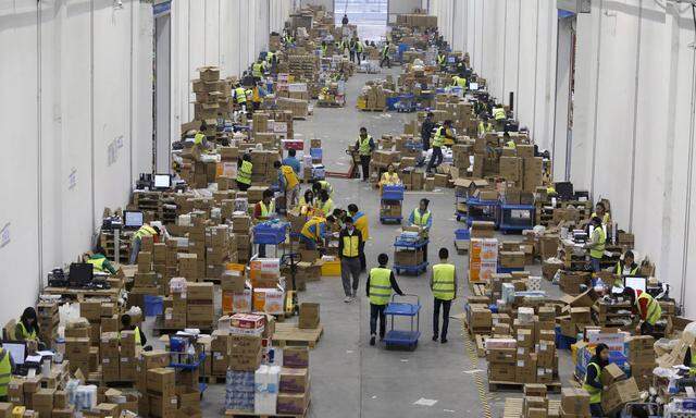 FILE PHOTO - Employees sort boxes and parcels at the logistic centre of a express delivery company, after the Singles Day online shopping festival, in Wuhan