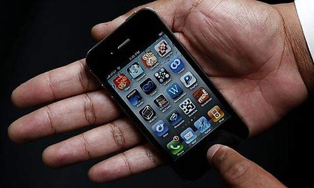 An Associated Press reporter holds the new Apple iPhone during a product test review in San Francisco