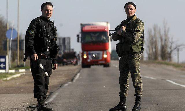 Ukrainian servicemen stand on guard at a checkpoint near the town of Armyansk