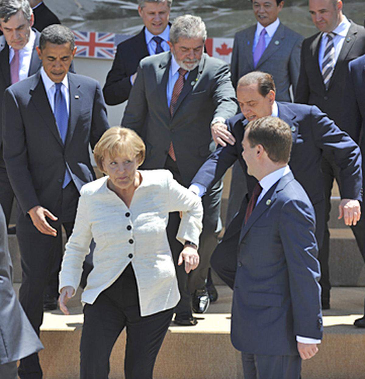 Ganz glücklich scheint Merkel über die "Hilfe" aber nicht zu sein, und auch die Staatschefs im Umfeld der Situation schauen etwas ratlos zu. Einzig der brasilianische Präsident Luiz Inacio Lula da Silva packt tatkräftig mit an.