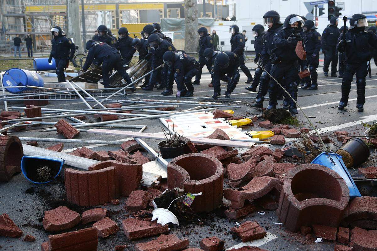 Erste Aufräumungsarbeiten begannen: Polizisten beseitigen die Reste von Straßenblockaden.