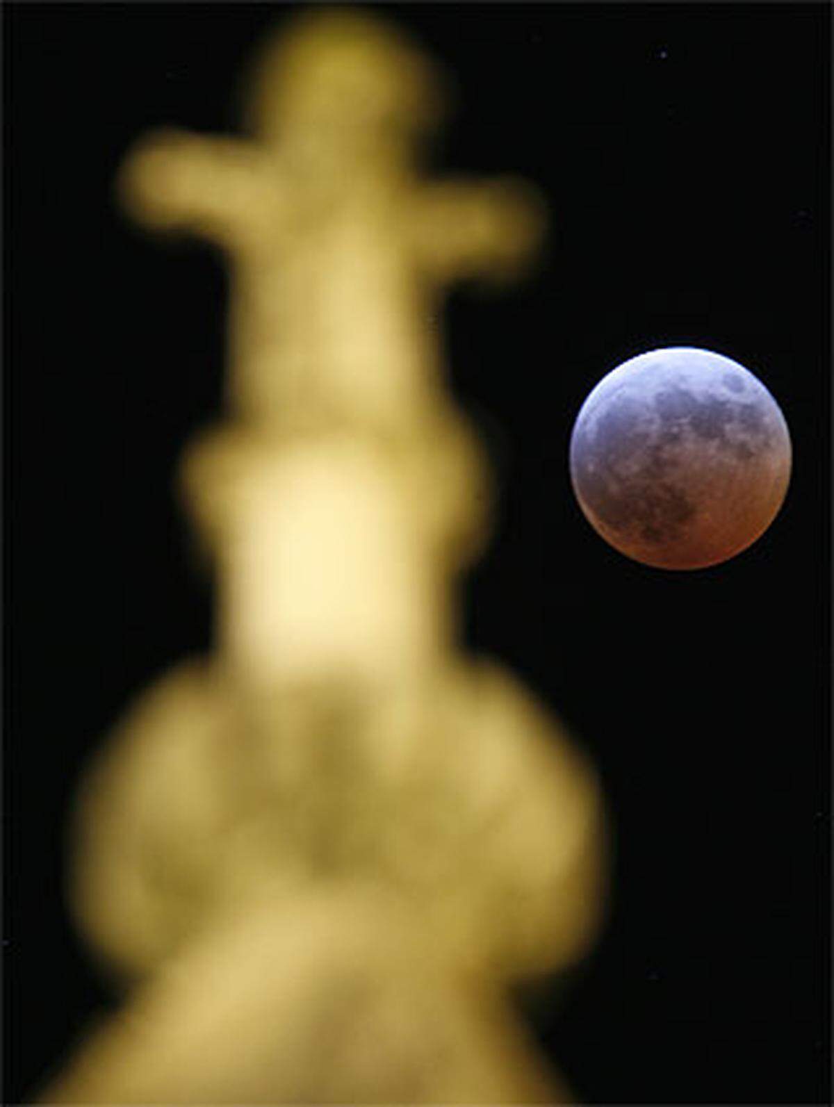 Der Mond hinter einer Skulptur der Kathedrale von Lausanne.
