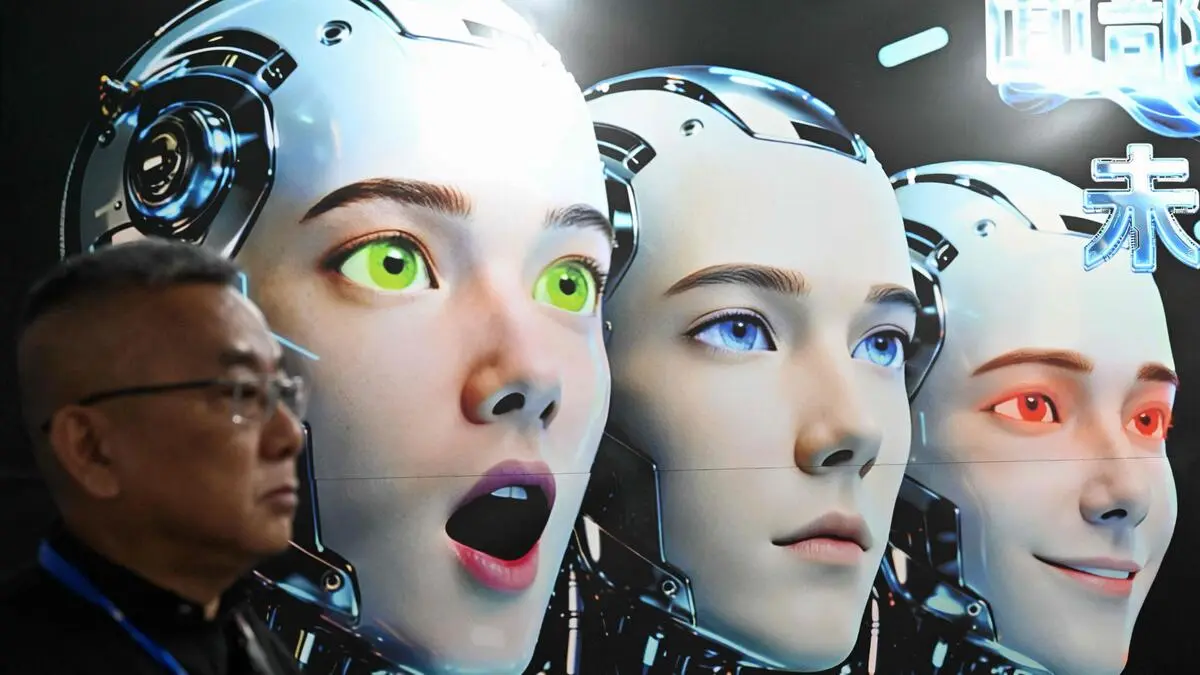 TOPSHOT - A man stands next to a poster showing robots mimicking human expressions from Shenzhen Xiaoquan Technology during the International AI Application and Robotics Innovation Exhibition in Beijing on March 18, 2026. (Photo by ADEK BERRY / AFP)
