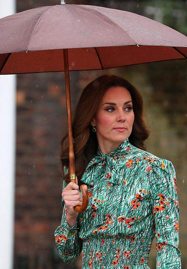 Naja, sehen wir es positiv: So hatte die Herzogin neben den beigen High Heels (von L. K. Bennett) und den grünen Monica-Vinader-Ohrringen noch ein weiteres Accessoire - einen rotbraunen Regenschirm. 