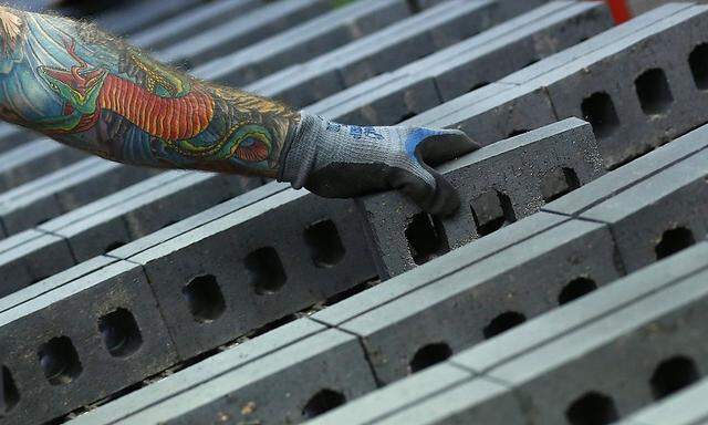 A worker checks the quality of bricks at the Wienerberger Brick Factory in Dosthill