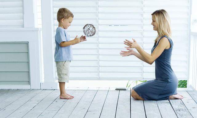 Mother and son playing catch on porch