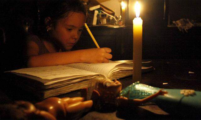 Venezuela: Ein Schulmädchen macht Hausaufgaben bei Kerzenlicht.