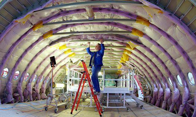 FILE PHOTO: A technician works inside the cabin of the first equipped fuselage sections of the new 555-seat superjumbo Airbus A380 at the Airbus facility in Finkenwerder near Hamburg