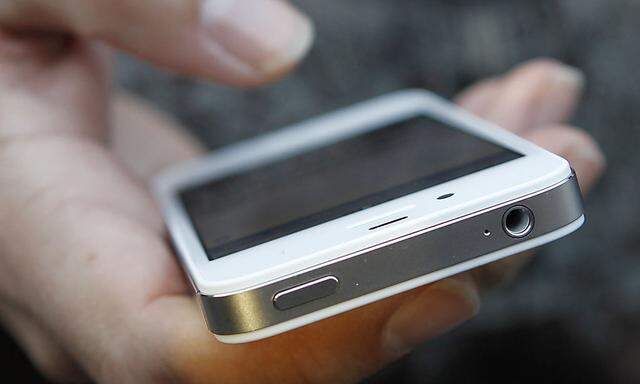 A customer uses his new iPhone 4S after making the purchase at Apple's flagship retail store in San Francisco