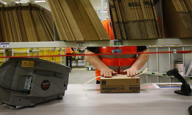 Worker handles items for delivery at Amazon´s new distribution center in Brieselang