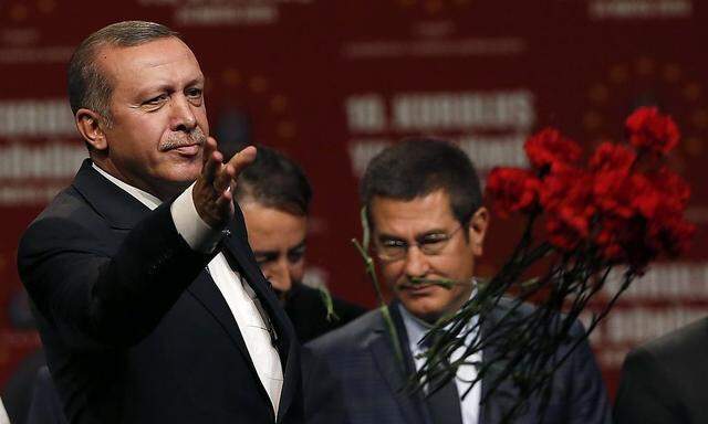 Turkish Prime Minister Erdogan throws flowers to his supporters during his visit in Cologne