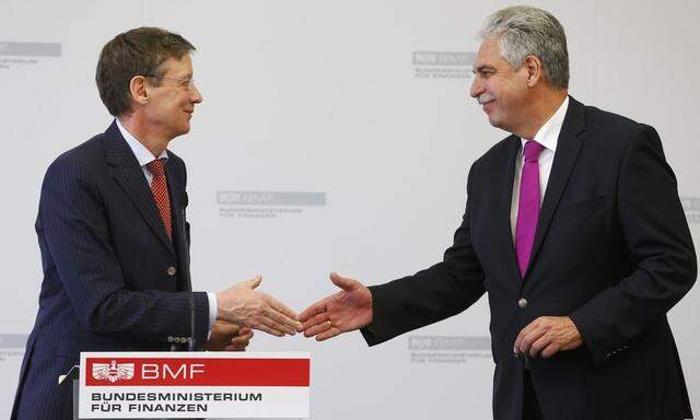 Austria's Finance Minister Schelling and spokesman for the umbrella group of Heta creditors Munsberg shake hands after a news conference in Vienna