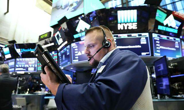 A trader works on the floor of the New York Stock Exchange (NYSE) near the close of market in New York