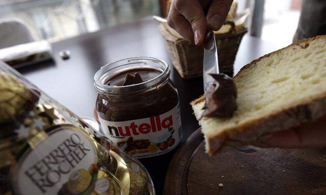 A woman spreads Nutella on a slice of bread in Milan