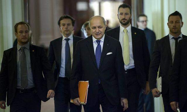 French Foreign Minister Laurent Fabius walks with others during a break in a meeting with world representatives seeking to pin down a nuclear deal with Iran at the Beau Rivage Palace Hotel in Lausanne
