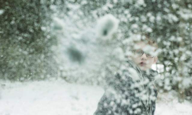 Boy throwing snowball against windscreen model released PUBLICATIONxINxGERxSUIxAUTxHUNxONLY PAF00042
