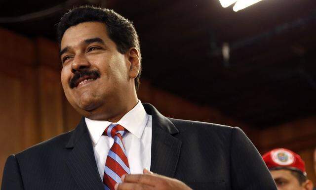 Venezuela's President Maduro smiles during a meeting with ministers and lawmakers of the National Assembly in Caracas