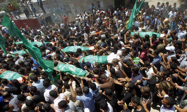 Mourners carry the bodies of Palestinian members of al Haj family who medics said were killed in an