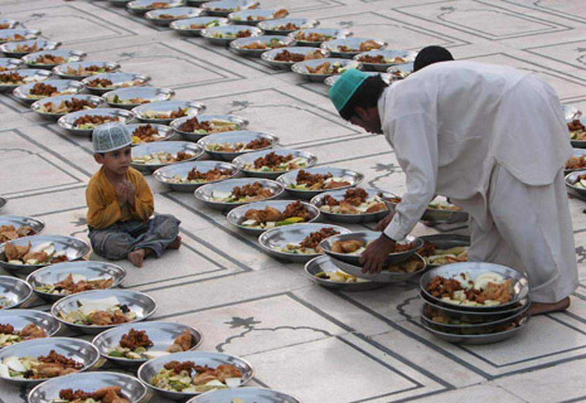 Mit dem Neumond am 11. August hat für mehr als eine Milliarde Muslime weltweit der Fastenmonat Ramadan begonnen. Er soll eine Zeit der Besinnung und der Festlichkeit sein, die mit dem abendlichen Fastenbrechen, dem "Iftar", besonders gefeiert wird.  Im Bild: Ein pakistanischer Mann richtet die Speisen für "Iftar" an - die Mahlzeit nach dem täglichen Fasten, gleich nach Sonnenuntergang.