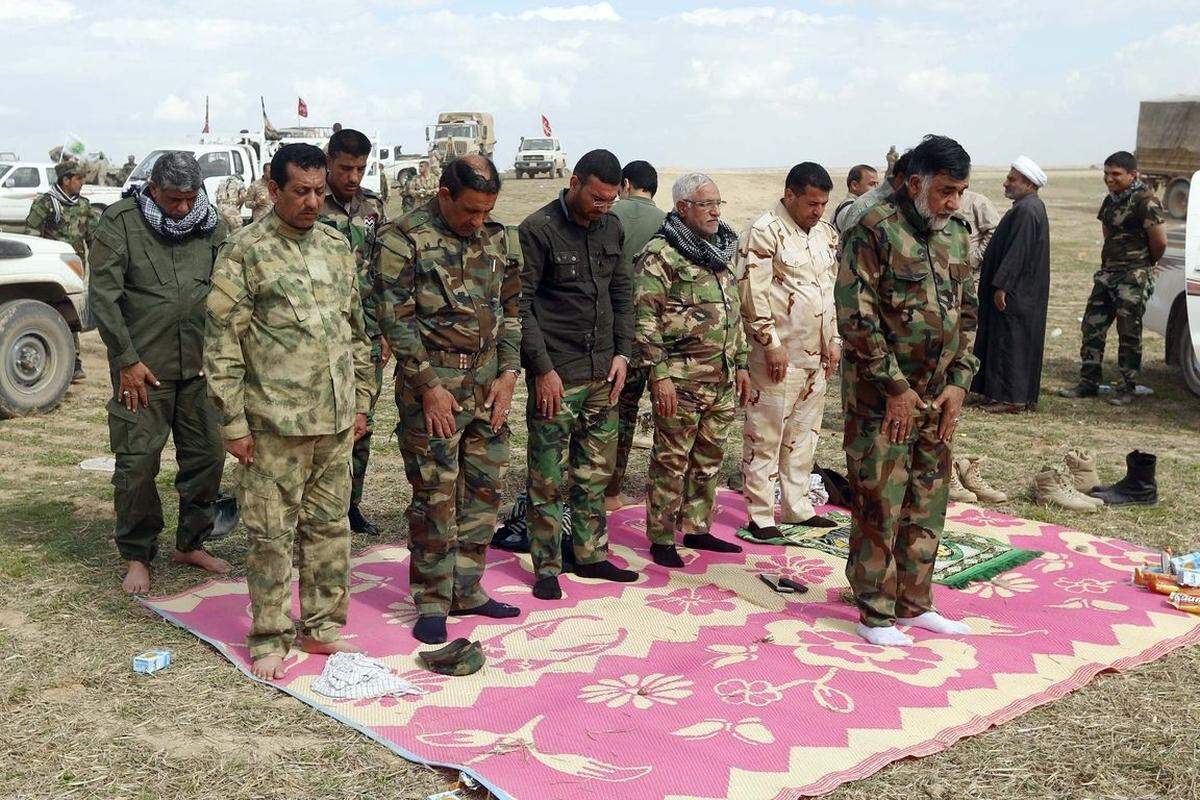 Iraks Armee ist allerdings nur deshalb zum Angriff auf die Stadt in der Lage, weil sie massive Hilfe von Freiwilligen bekommt.Bild: Schiitsche Kämpfer beten an der Front.