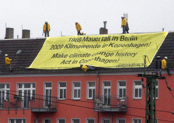 Zur selben Zeit auf einem Dach nahe des ehemaligen Grenzübergangs Bornholmer Straße: Greenpeace-Aktivisten nutzten die Feierlichkeiten, um für ein neues, wirksames UNO-Klimaschutzabkommen zu demonstrieren.