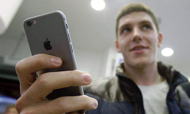 A customer holds the newly released iPhone 6 at a mobile phone shop in Moscow