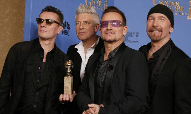 U2 pose backstage with their award for Best Original Song for' Ordinary Love' from the film 'Mandela: Long Walk to Freedom' at the 71st annual Golden Globe Awards in Beverly Hills