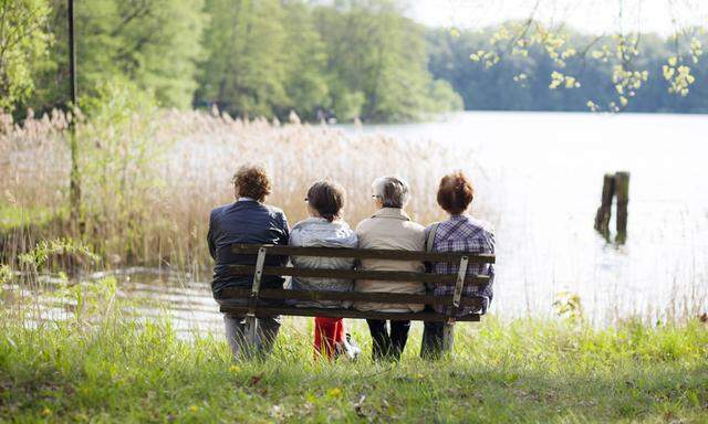 Vier Seniorinnen sitzen im Ort Flecken Zechlin bei Rheinsberg in Brandenburg auf einer Bank Seniori