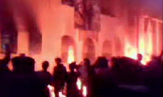 Ein Bild aus einem Amateurvideo zeigt Menaschen vor einem brennenden Polizeirevier in Tobruk 