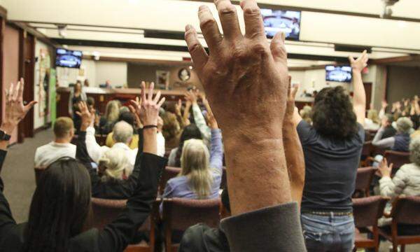 School Board Meeting in Florida. Diese Teilnehmer sprechen sich via Handzeichen gegen Bücherverbote aus.  