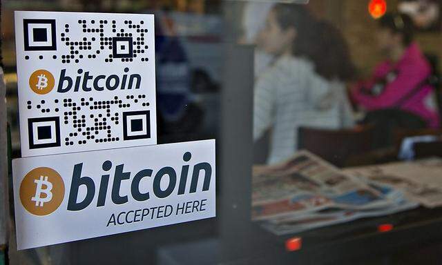 Signs on window advertise bitcoin ATM machine that has been installed in a Waves Coffee House in Vancouver