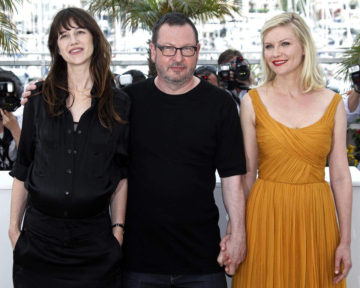 Kirsten Dunst (in einem Kleid von Chloé) und die hochschwangere Charlotte Gainsbourg umzäunten den teils in Verruf geratenen Regisseur Lars Von Trier bei der Pressekonferenz seines neuesten Streifens "Melancholia". Warum sich Von Trier als Nazi fühlt und wieso er in Cannes unerwünscht ist, lesen Sie hier.