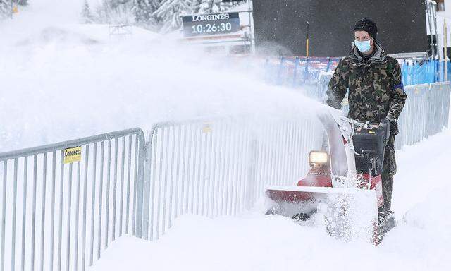 Arbeiter räumt Schnee im Zielgelände
