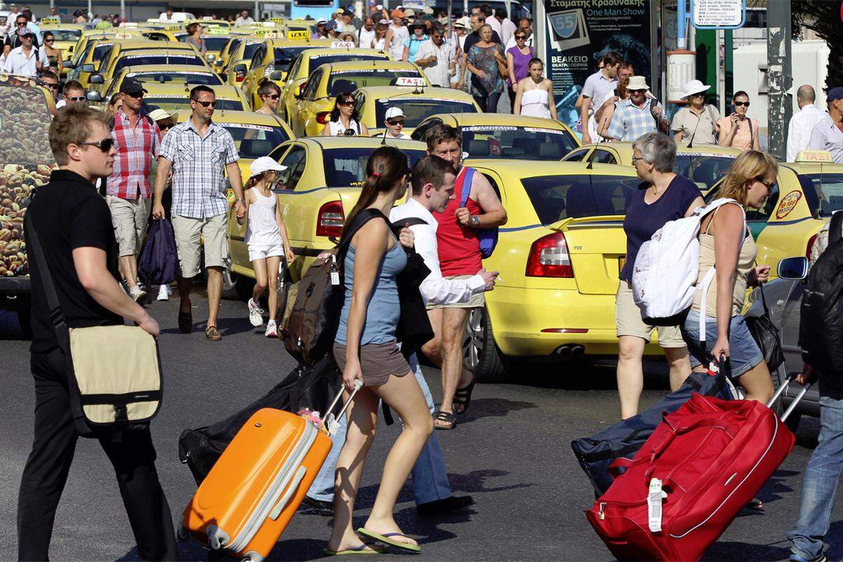 Tausende Urlauber mussten ihr Gepäck in der Hitze zu Fuß zu den Fähranlegern schleppen.