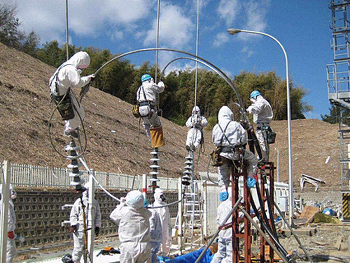 Hohe Radioaktivität, Hitze und aufsteigender Rauch - die Arbeiten am AKW Fukushima müssen immer wieder unterbrochen werden und kommen nur mühsam voran.Im Bild: An der Herstellung der Stromversorgung für die Reaktoren 3 und 4 wird gewerkt.