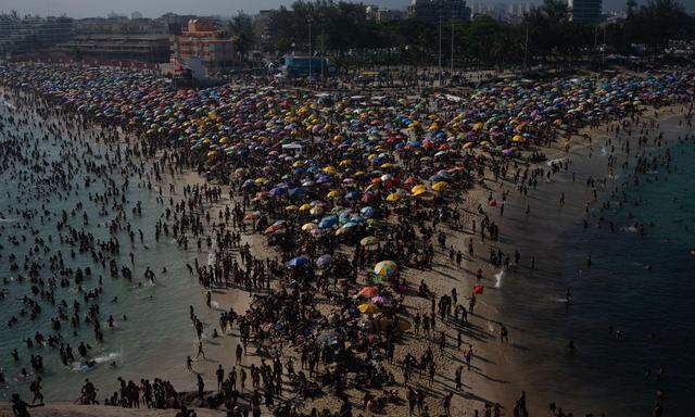 (FILES) Sunbathers enjoy Macumba beach, in the west zone of Rio de Janeiro, on September 24, 2023, during a heat wave which registered 39.9 degrees. The heat wave gripping much of Brazil for the last days continued on November 14, 2023, with sweltering temperatures in cities such as Rio de Janeiro, where the wind chill reached a record high of 58.5¡C, officials said. (Photo by Tercio Teixeira / AFP)