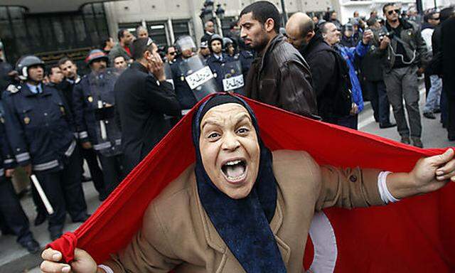A protester with a Tunisian flag shouts slogans against President Zine El Abidine Ben Ali  in Tunis, 