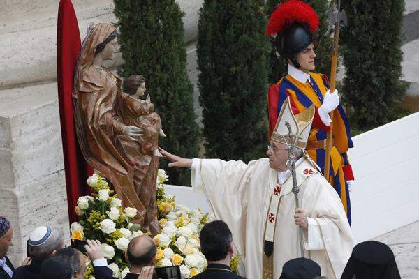 Papst Franziskus berührt eine Marienstatue vor der Zeremonie. In seiner Predigt würdigte Franziskus die beiden neuen heiligen Päpste als mutige Glaubenszeugen des 20. Jahrhunderts und Erneuerer der Kirche.