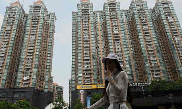 Eine Frau passiert einen Häuserkomplex des chinesischen Immobilienunternehmens Evergrande in der südlichen Provinz Guangdong. Der hochverschuldete Konzern ist schwer in Schieflage geraten.