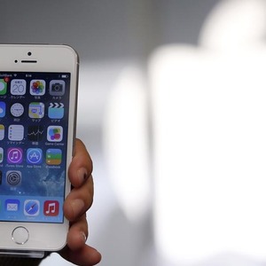 File photo of a woman holding her new Apple iPhone 5S after buying it at an Apple Store at Tokyo´s Ginza shopping district