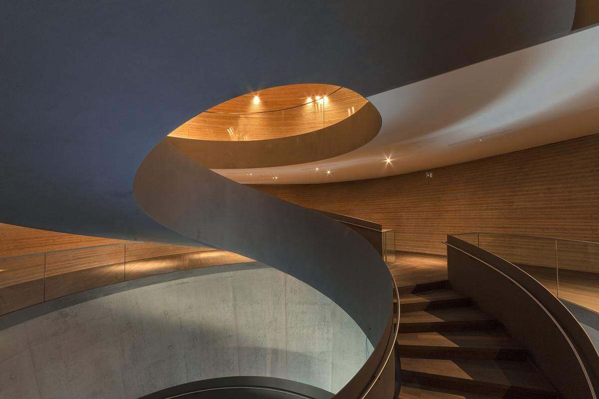 Die Treppe führt zu den beiden Ausstellungsebenen, wo die Objekte mit Hilfe von in die Architektur integrierten Wänden, Tischen und Vitrinen präsentiert werden.