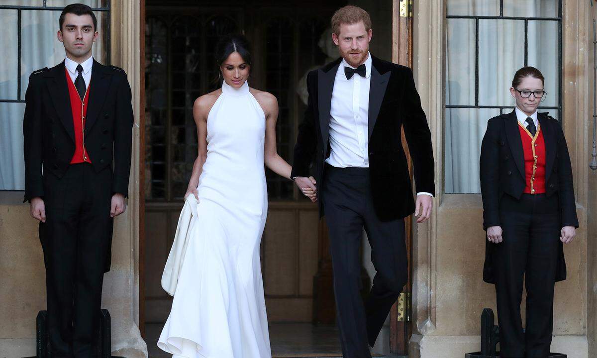 Als Meghan und Harry abends in ihrem Jaguar zur Party in Frogmore House entschwanden, zeigte sich die Braut in einem klassischen Neckholder-Kleid der britischen Designerin Stella McCartney. Dazu trug Harrys Angetraute einen großen Aquamarin-Ring, der einst seiner Mutter Prinzessin Diana gehört hatte.