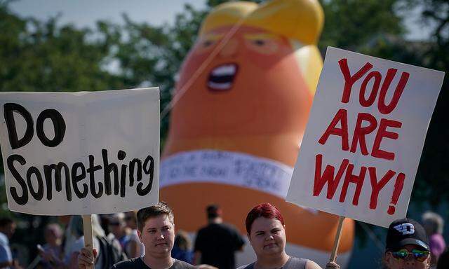 Protestors rally around a baby Trump balloon near Miami Valley Hospital in Dayton