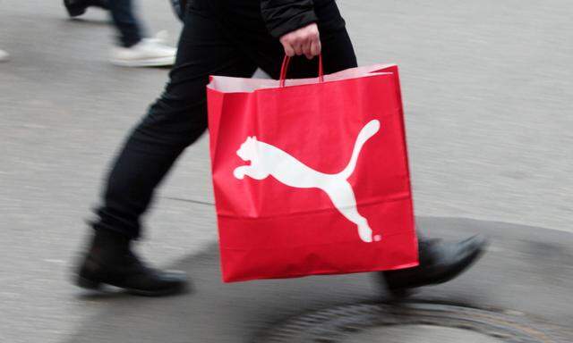 Passant mit Einkaufstasche des Sportartikel Unternehmen s Puma eilt durch die Innenstadt M�nchen