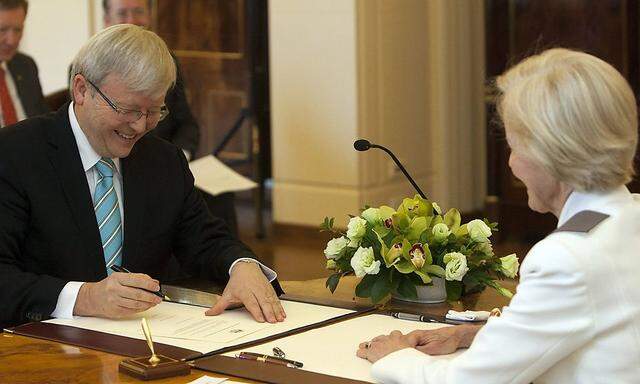 Kevin Rudd signs his commission as Prime Minister of Australia as Governor-General Quentin Bryce looks on at Government House in Canberra