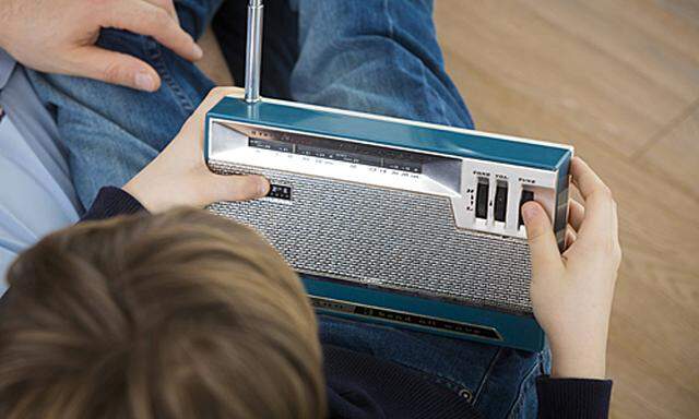 Father and son listening to an old radio model released Symbolfoto property released PUBLICATIONxINxGERxSUIxAUTxHUNxONL