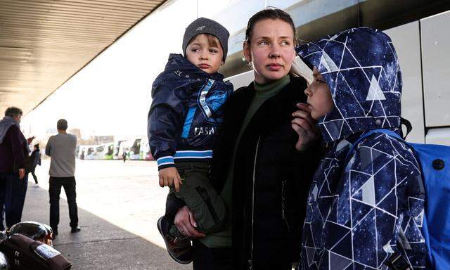 Ukrainische Flüchtlinge warten an einer Busstation in Warschau auf die Heimreise.
